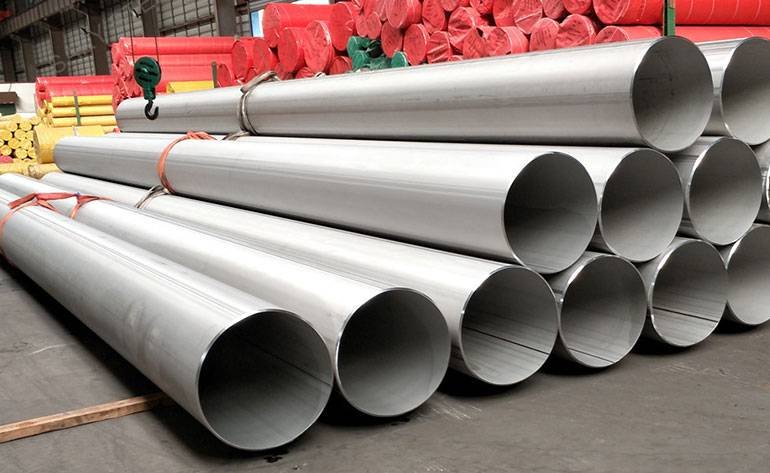 Stacked 304H stainless steel industrial pipes in a warehouse storage yard
